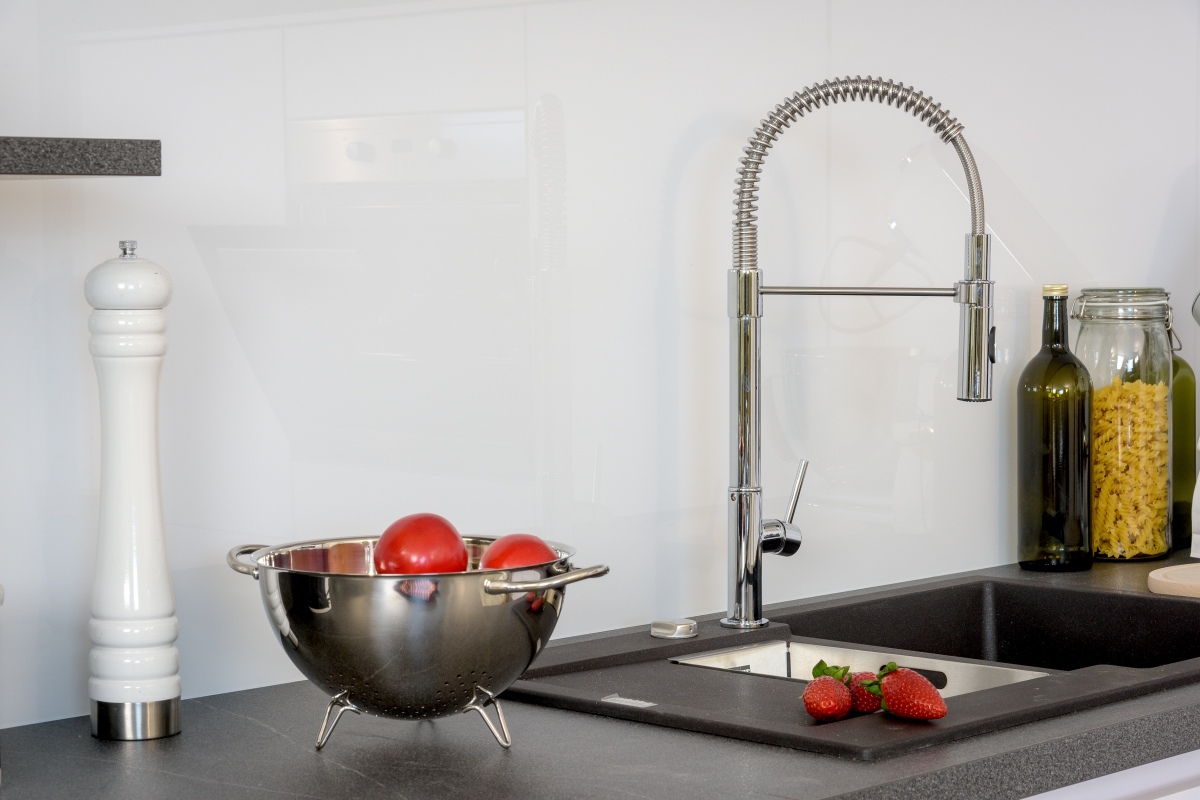 Küchenspüle mit besonderer Armatur aus Edelstahl auf dunklen Spülbecken