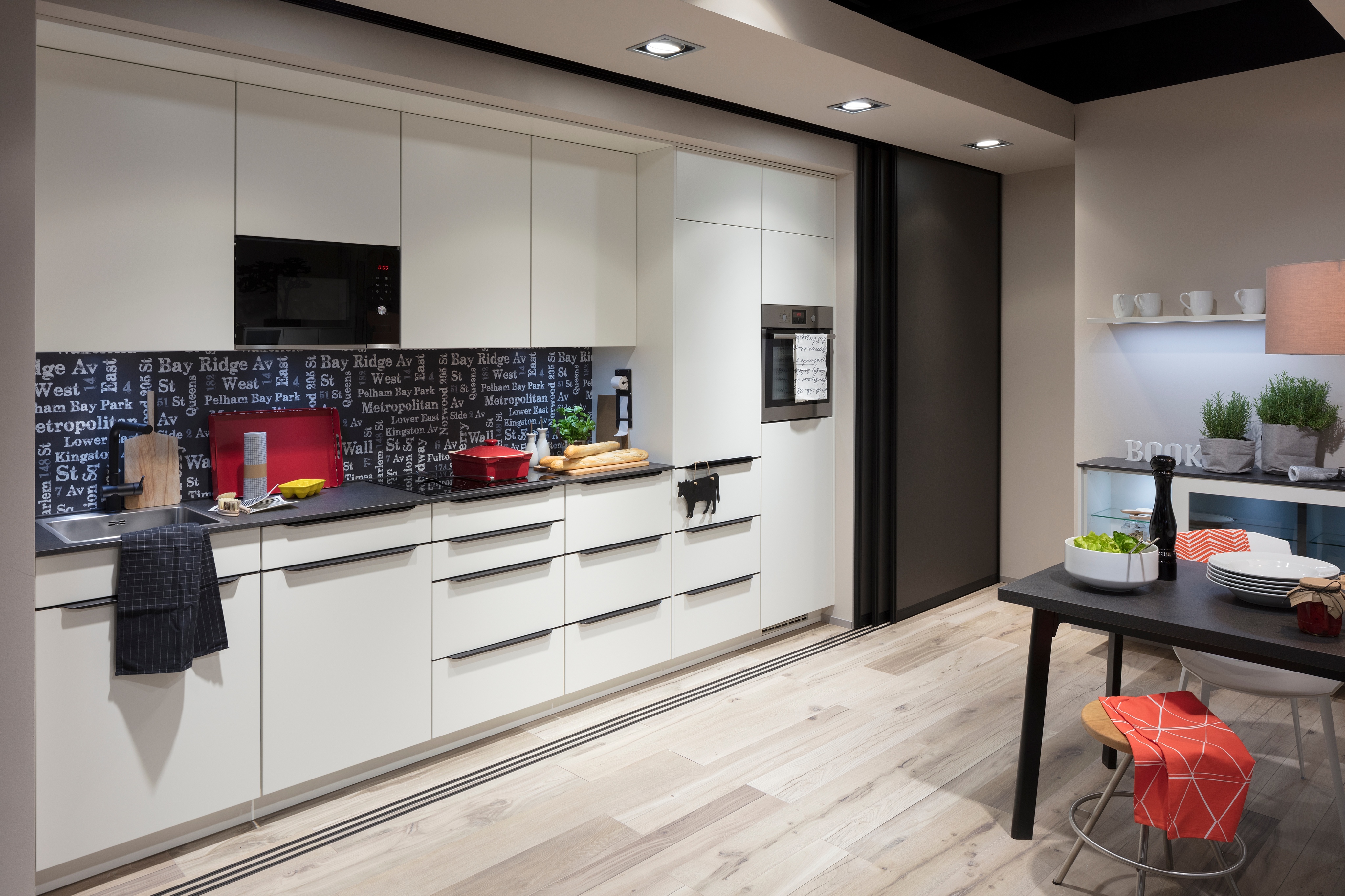 Helle Küche mit Esszimmertisch, Hockern und Nischenrückwand