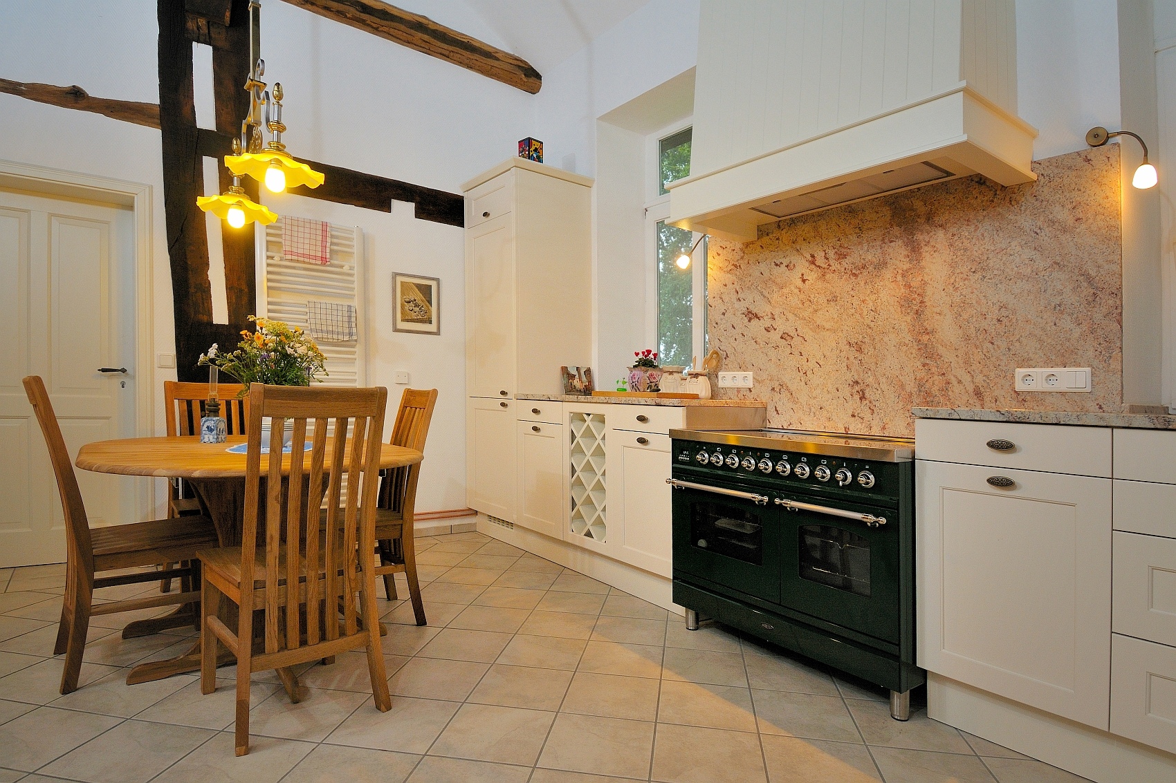 Helle Landhausküche mit Stühlen und rundem Esszimmertisch