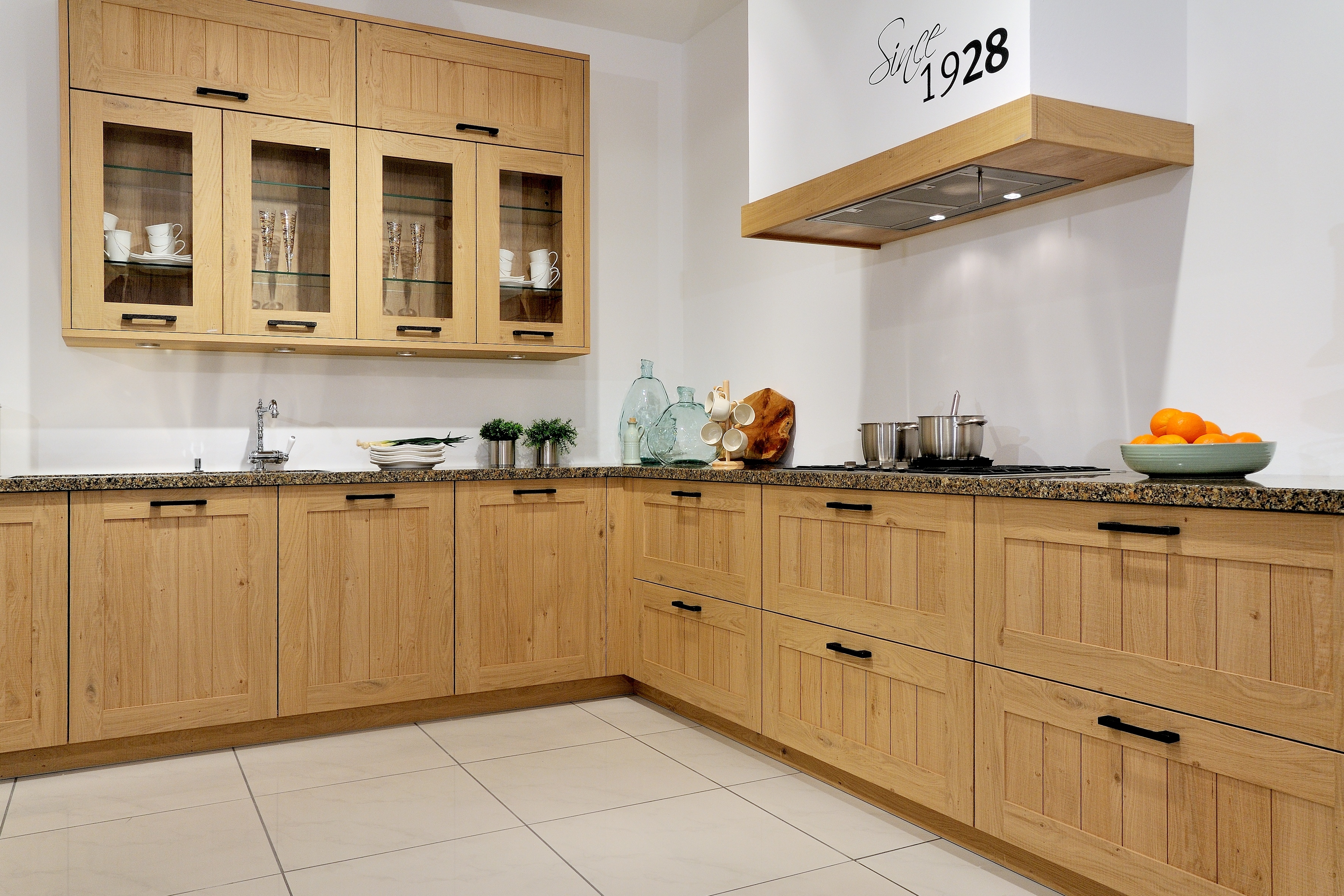 Landhausküche mit verglasten Schränken und Marmorarbeitsplatte