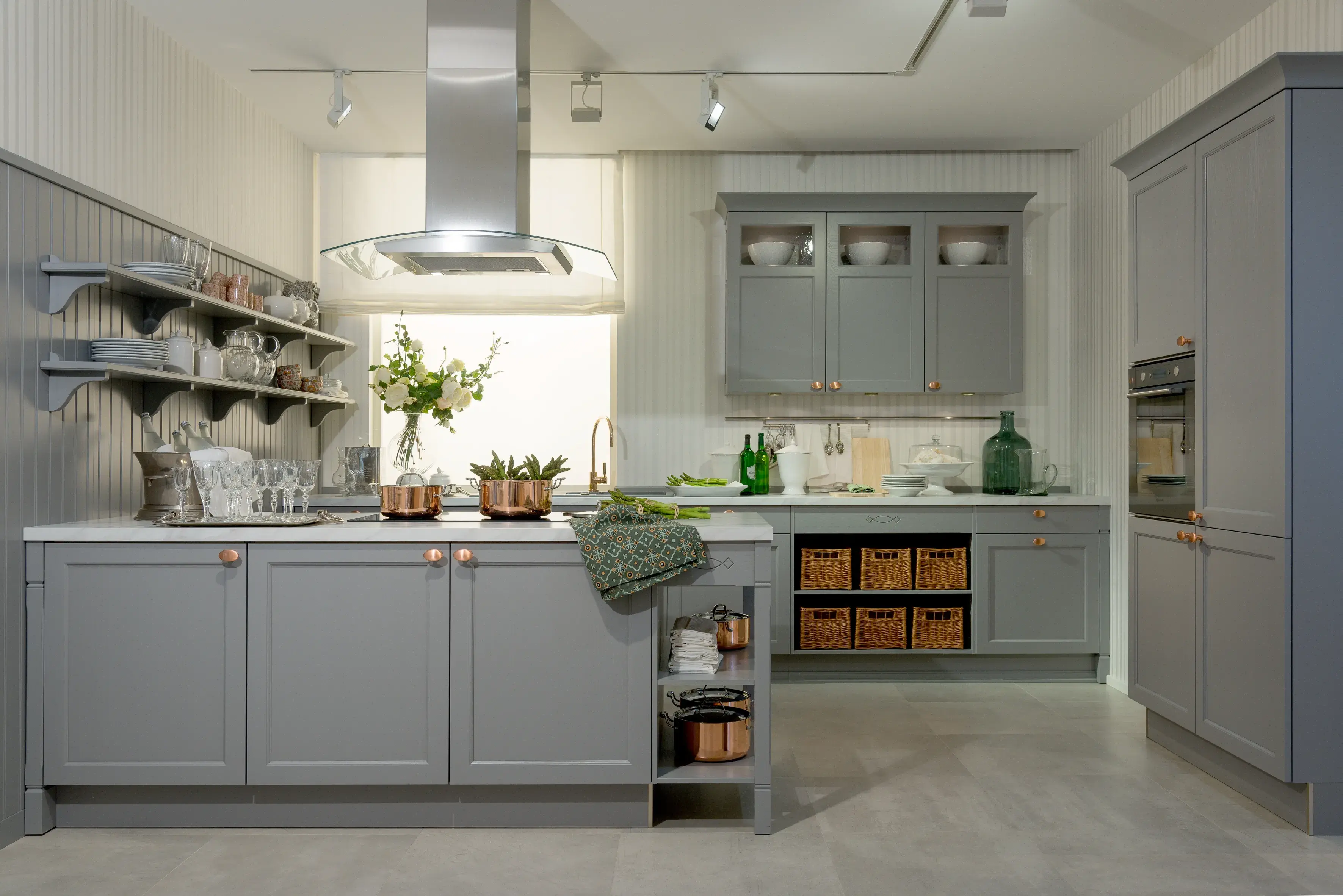 Hellgraue Landhausküche aus Holz mit Regalen, hohen Oberschränken, Abzugshaube
