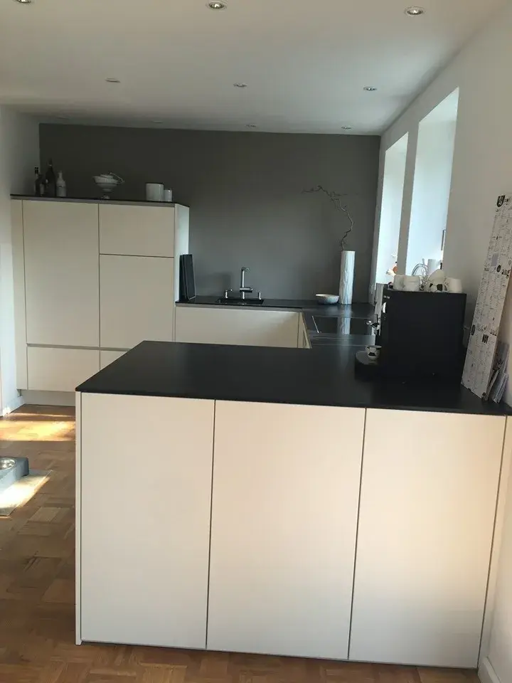 Kundenküche in Bremen mit weißen Fronten und schwarzer Arbeitsplatte