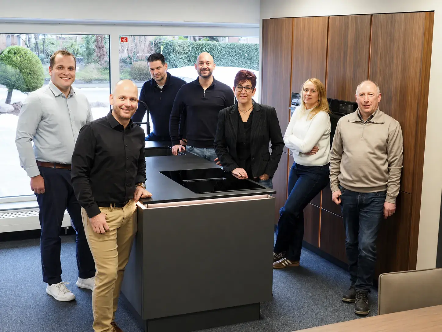 Team vom Küchenstudio Detken - um Kücheninsel versammelt